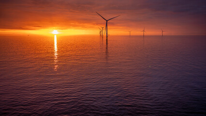 Sunset offshore at wind turbine farm