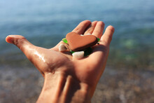 Heart Stone Shape In Man Hand With Crystal Pebbles On The Beach. Love And Nature , Simple Things That Makes Us Happy Concept 
