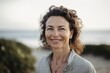 © Hanne Bauer - Portrait of smiling woman looking at camera on beach in the morning