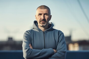 Wall Mural - Portrait of a man in a hooded jacket on the background of the city