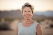 © Anne-Marie Albrecht - Lifestyle portrait photography of a satisfied woman in her 50s wearing a casual t-shirt against a desert background. Generative AI