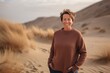 Medium shot portrait photography of a pleased woman in her 40s wearing a cozy sweater against a sand dune background. Generative AI