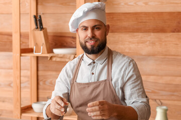 Canvas Print - Male baker cooking at table in kitchen