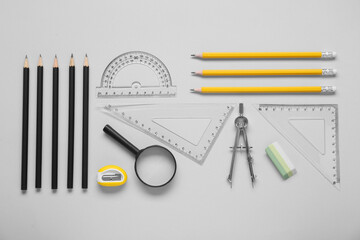 Wall Mural - Flat lay composition with different rulers and compass on light grey background