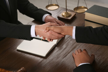 Wall Mural - Law and justice. Notary with client shaking hands at wooden table, closeup