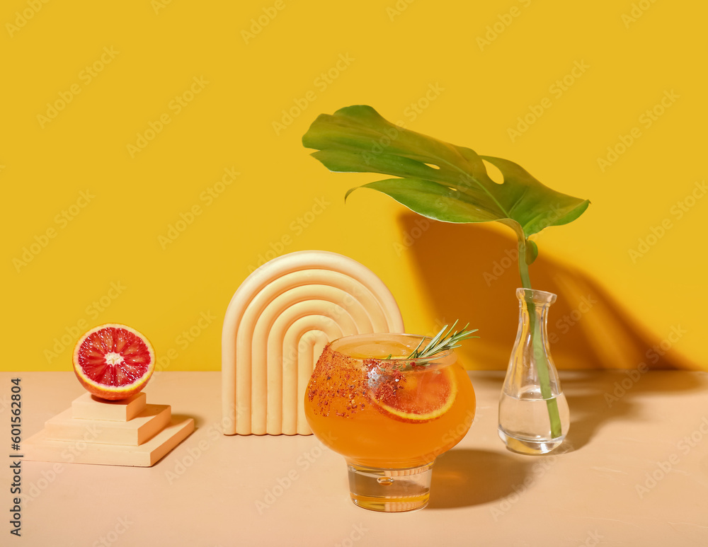 Fresh summer cocktail with grapefruit and rosemary on orange background