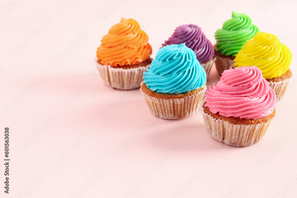 Tasty colorful cupcakes on pink background