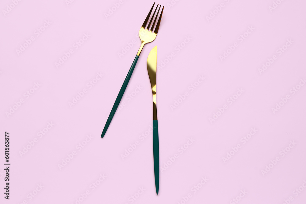 Stainless steel fork and knife on lilac background