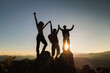 © Tinnakorn - Silhouette of happy teamwork with success gesture standing on the top of mountain, business teamwork concept, business victory, achieve business goal.