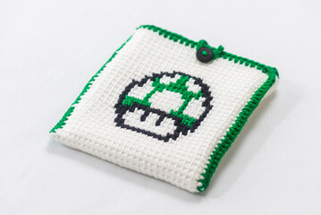 envelope for external hard drive, crocheted with a green mushroom drawn