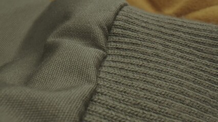 Close-up of a wool jacket on a yellowish colored blanket.