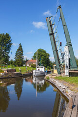 Wall Mural - Boat in a canal with an open road bridge