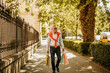 © La Famiglia - Handsome elegantly dressed mature man walking with shopping bags through the city park.