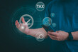 © 418studio - financial research government tax and calculation tax return concept Businessman showing holographic tax on hand Online tax return form filling concept for payment, online marketing, business process.
