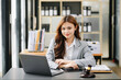 © Nuttapong punna - Beautiful Asian woman using laptop and tablet while sitting at her working place. Concentrated at office