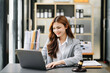 © Nuttapong punna - Beautiful Asian woman using laptop and tablet while sitting at her working place. Concentrated at office