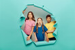 © LIGHTFIELD STUDIOS - Shocked multiethnic preteen kids in colorful t-shirts looking at camera while celebrating child protection day behind hole in blue paper background