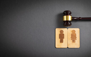 Canvas Print - Judge gavel with a male and female wooden symbols on the black background.