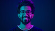 © Yuliia - Portrait Indian man Muslim guy developer coding worker smile computer internet technology hacker Arabian male in glasses smiling neon blue ultraviolet studio background high-tech future cyberspace