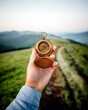 Tourist with old compass in hand on mountains road. Travel concept. Landscape photography