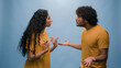 © Yuliia - Multiracial couple quarrel offended Arabian Indian man husband argue with angry Latino Hispanic woman wife conflict misunderstanding problem bad relationship family divorce in blue studio background
