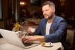 © Viacheslav Yakobchuk - Man booking vacation tour drinking coffee at lobby-bar