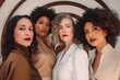 © ADDICTIVE STOCK - Generative AI illustration of a diverse group of female models with stylish clothes and curly hair, makeup with painted lips looking at the camera against a decorated white wall