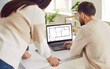 © Studio Romantic - Two architects or interior designers working with design project of apartment on laptop. Couple looking at blueprint of architecture plan apartment set discussing engineering floor plan.