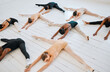 © Kirsten D/peopleimages.com - .Ballet, students and leg stretching floor together for balance, exercise and flexibility training class from above. Art, dance studio and wellness, people stretch for fitness and creative dancing.