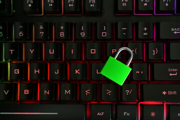 Cyber Security Concept - green padlock lock on colorful lit laptop computer keyboard keys