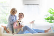 © famveldman - Mother and child with air conditioner remote