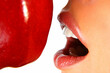 closeup of a womans lips and teeth eating an apple