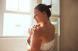 © Chanelle Malambo/peopleimages.com - Skincare, body cream and woman in bathroom for wellness, moisturizer and apply lotion for healthy skin. Beauty, self care and female person for grooming, shower and cosmetics for hygiene at home