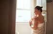 © Chanelle Malambo/peopleimages.com - Skincare, cream and woman in bathroom for body wellness, moisturizer and apply lotion for healthy skin. Beauty, self care and female person for grooming, shower and cosmetics for hygiene at home