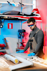 confident male technician working on drone details in lab. aircraft capable of gps surveillance. car