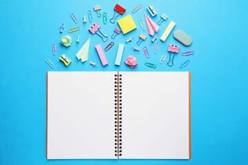 Wall Mural - Back to school. School stationery and paper planes near notebook on light blue background, flat lay
