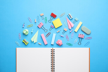 Wall Mural - Back to school. School stationery and paper planes near notebook on light blue background, flat lay