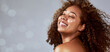 © Chanelle Malambo/peopleimages.com - Hair, space and African woman on banner with wind in studio for beauty, wellness and bokeh on grey background. Skincare, smile and happy model face with skin health, glow and relax with luxury mockup