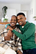 © Wavebreak Media - Portrait of happy african american young man with hand on boyfriend's shoulder sitting on sofa
