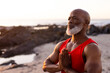 © Wavebreak Media - Focused senior african american man practicing yoga and doing pose at beach