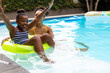 © Wavebreak Media - Happy african american mother and daughter playing with inflatable in swimming pool, copy space