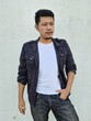 © Igunt - Cool modern young hipster man with a stylish hairstyle in a white T-shirt puts on a vintage black denim jacket. Attractive urban guy posing near a white wall. Fashionable spring menswear.