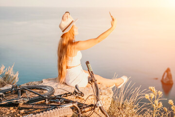 Woman travel sea. Happy tourist in hat enjoy taking picture outdoors for memories. Woman traveler posing on the beach at sea surrounded by volcanic mountains, sharing travel adventure journey