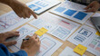 © Worapon - Close-up ux developers and ui designers use augmented reality to brainstorm on mobile app interface wireframe designs on modern office desks. Creative digital development office