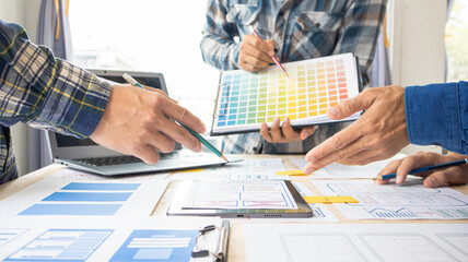 Close-up ux developers and ui designers use augmented reality to brainstorm on mobile app interface wireframe designs on modern office desks. Creative digital development office