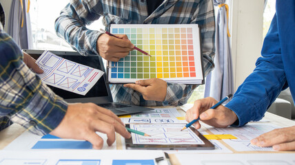 Close-up ux developers and ui designers use augmented reality to brainstorm on mobile app interface wireframe designs on modern office desks. Creative digital development office