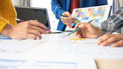 Close-up ux developers and ui designers use augmented reality to brainstorm on mobile app interface wireframe designs on modern office desks. Creative digital development office