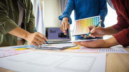 Close-up ux developers and ui designers use augmented reality to brainstorm on mobile app interface wireframe designs on modern office desks. Creative digital development office