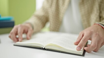 Sticker - Young hispanic man student opening book at library university