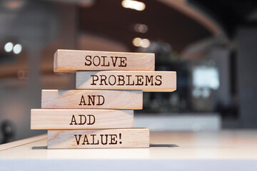 Wall Mural - Wooden blocks with words 'Solve problems and add value'.